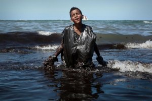 FOTO DE JOVEM COBERTO DE PETRÓLEO NUMA PRAIA NO BRASIL TORNA-SE VIRAL