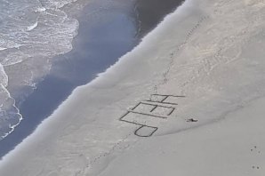 Surfista encontrado sem sentidos em praia remota após escrever “help” na areia