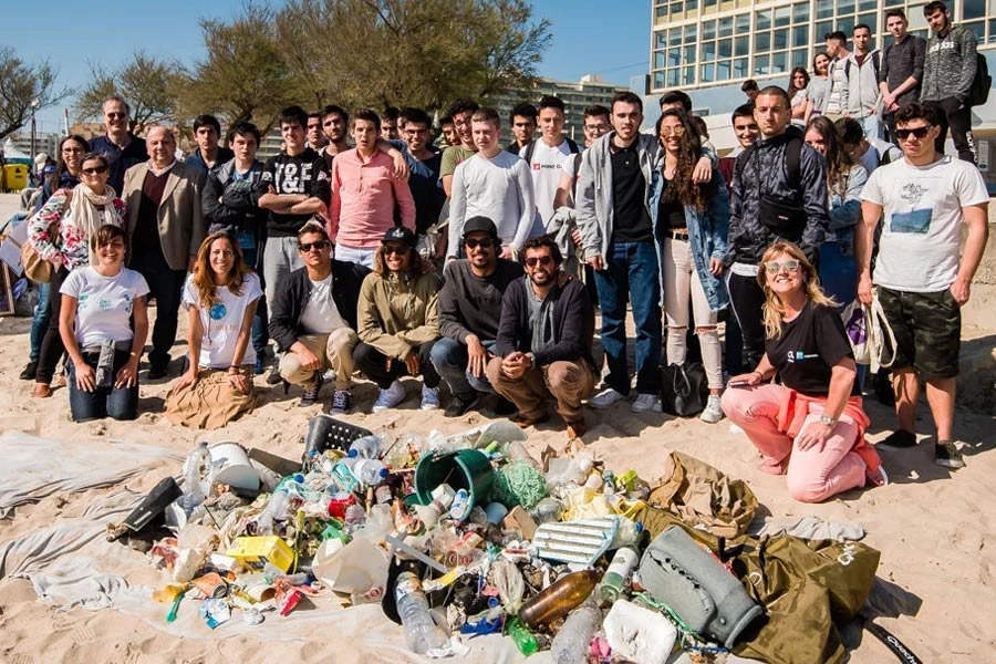 O grupo da limpeza de praia com alunos de escolas locais e os surfistas da Liga.